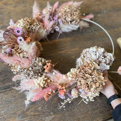 A woman making a wreath of dried flowers